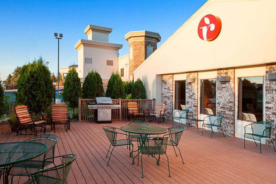 Outdoor patio with BBQ grill, tables, and chairs at Ramada by Wyndham Wisconsin Dells